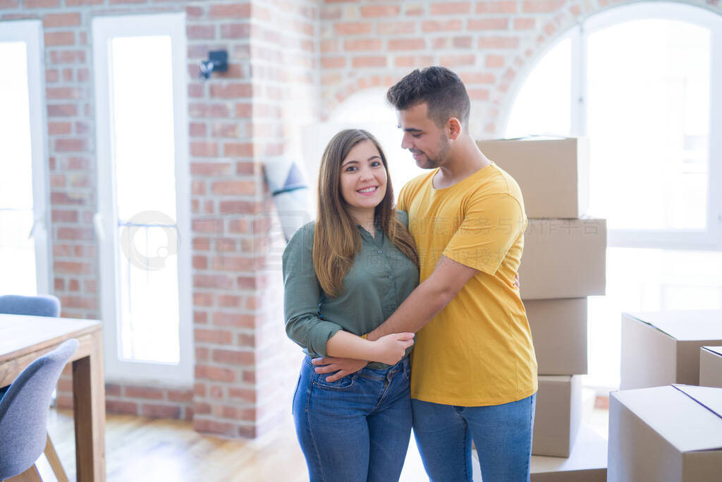 Young beautiful couple in love around cardboard boxes moving to