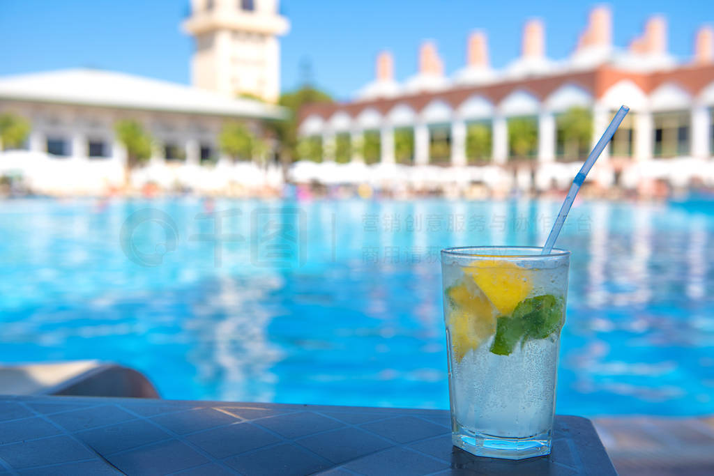 Refreshing alcoholic mojito drink stands by the pool on a hot su