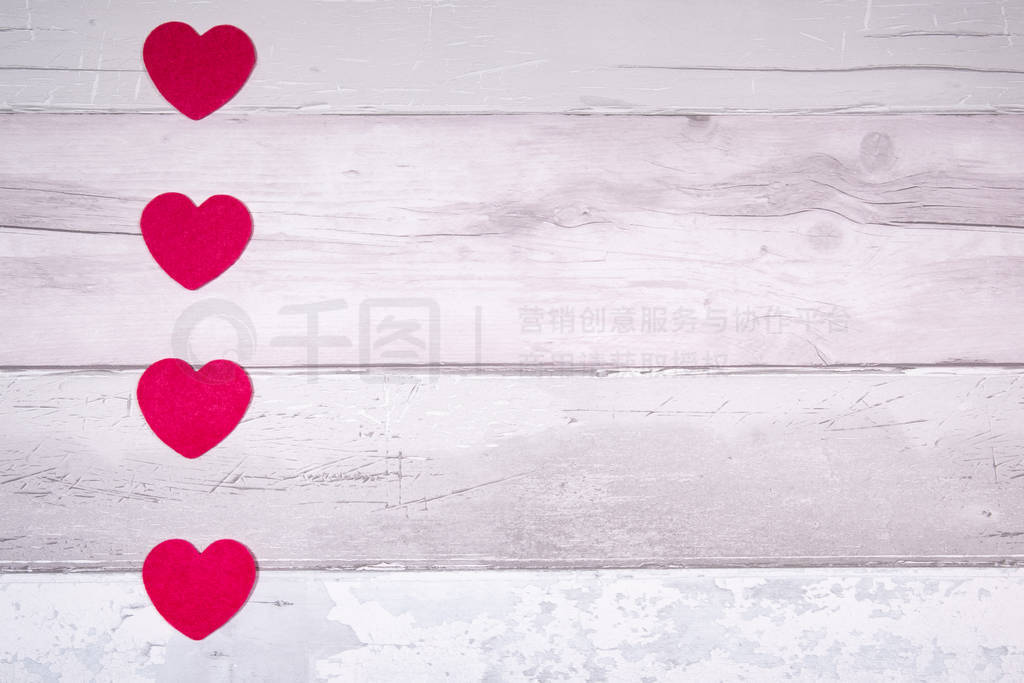 Red felt hearts on a background of old wooden planks resembling