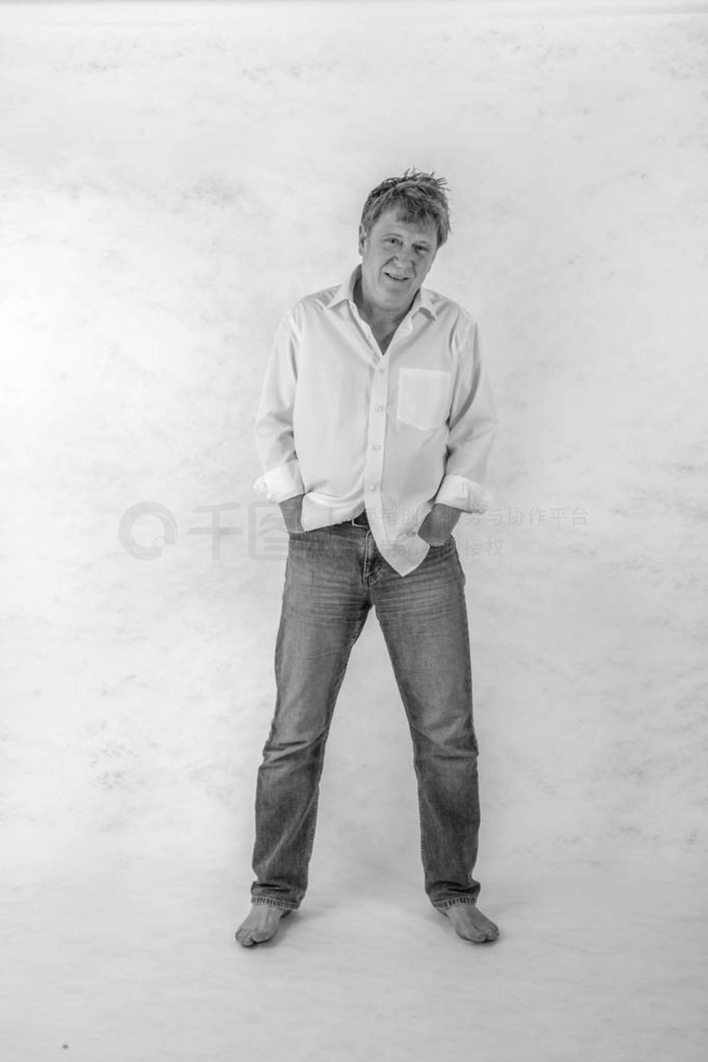 Mature man standing up against a white background