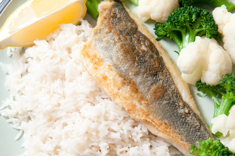 地中海海鲈鱼疏浚白米饭, 青花菜, 花椰菜和一片柠檬大米面粉中