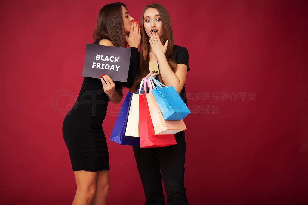 Elegant brunette women wears black dress holding shopping bags,