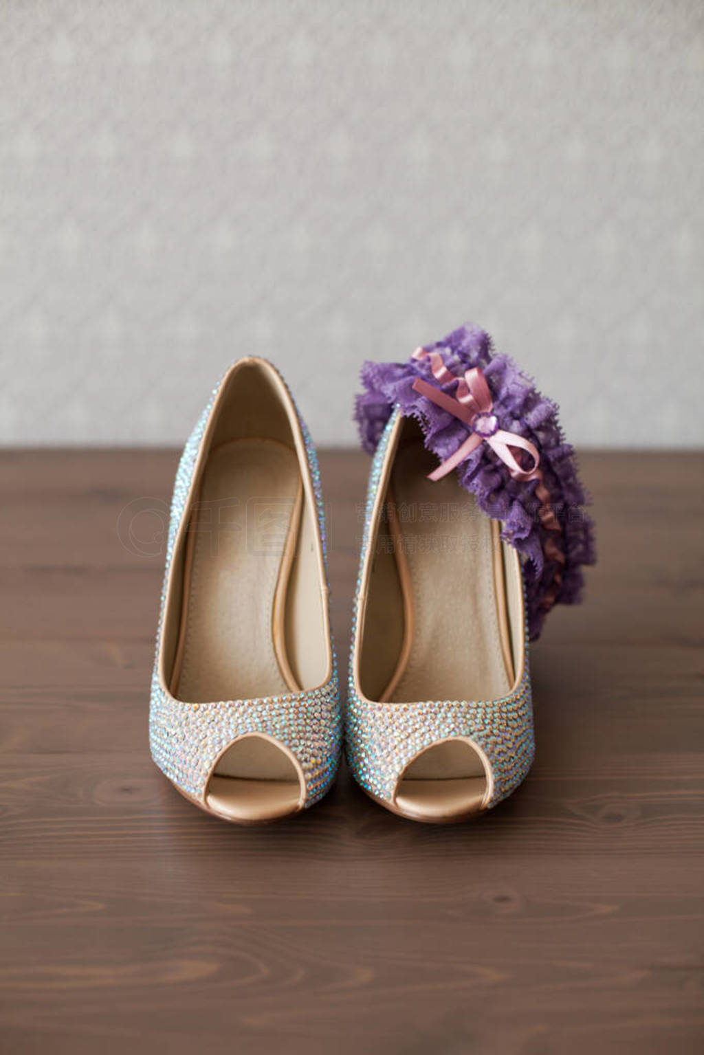 Elegant wedding shoes with colored rhinestones on the wooden flo