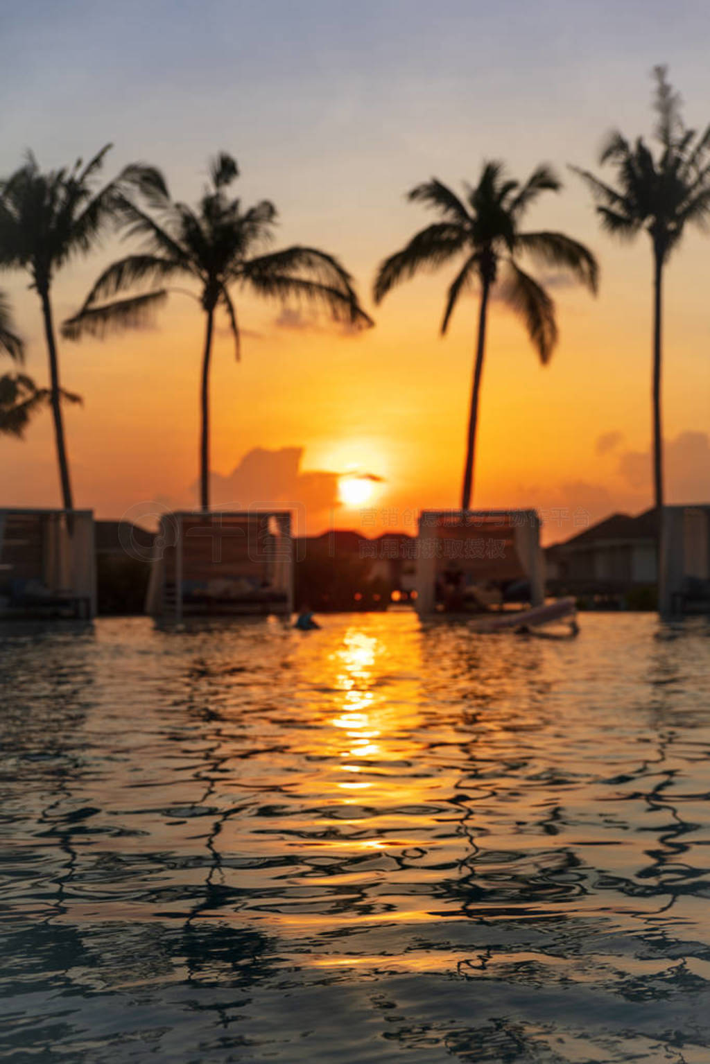 Orange Tropical sunset with swimming pool water reflection and p