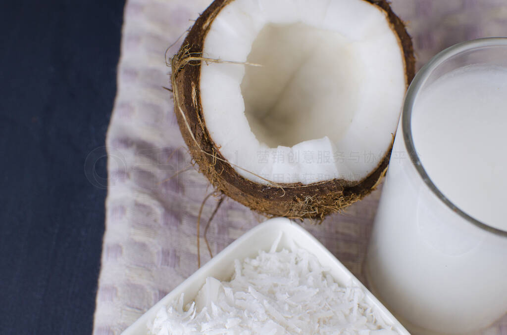 Coconut, coconut shavings and coconut milk on a black background