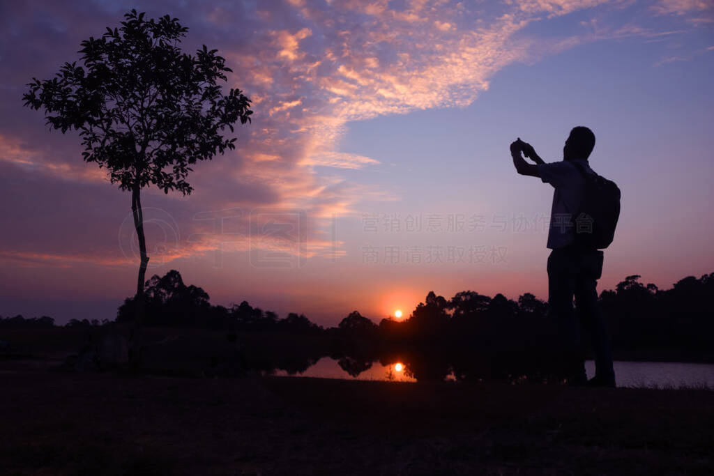 Photographer taking pictures outdoors, silhouette of a man with