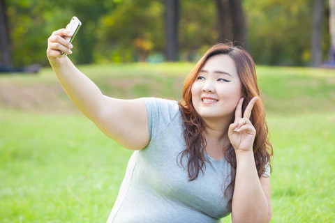 女人011夫人購物者考慮平板電腦與風趣的自拍照010現代技術休閒和生活