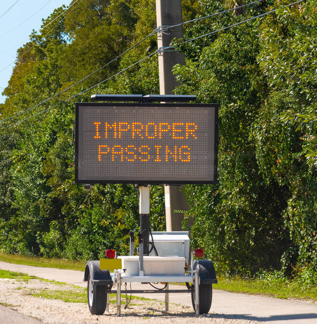 Improper passing written on a solar powered mobile road sign