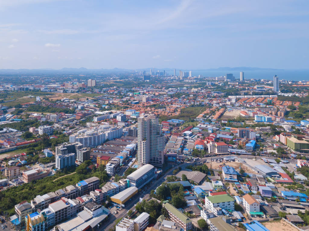 Aerial view of boats in Pattaya sea, beach, and urban city with