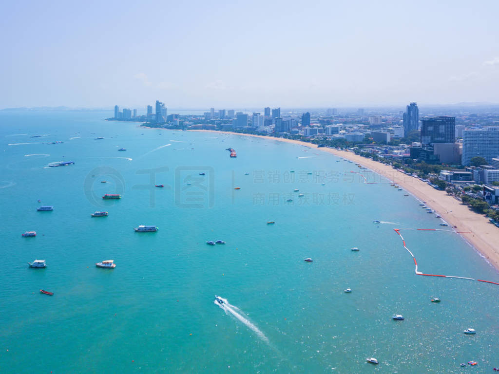 Aerial view of boats in Pattaya sea, beach, and urban city with