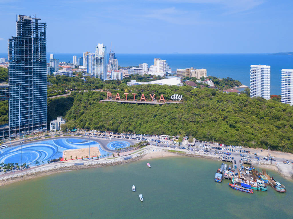 Aerial view of boats in Pattaya sea, beach, and urban city with