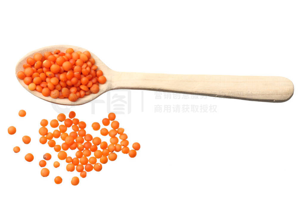 red lentils in wooden spoon isolated on white background. Top vi