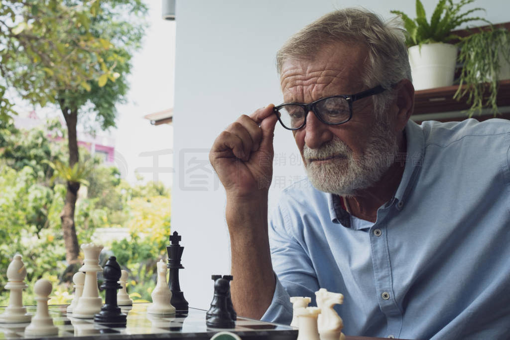 senior man happiness thinking and playing chess at balcony near