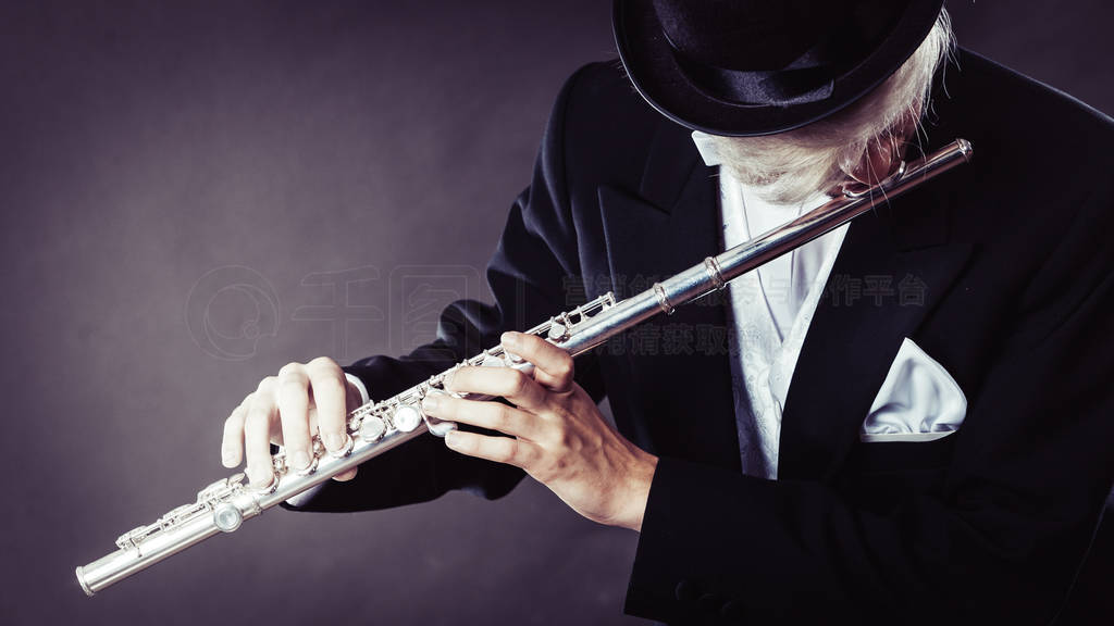 Elegantly dressed male musician playing flute