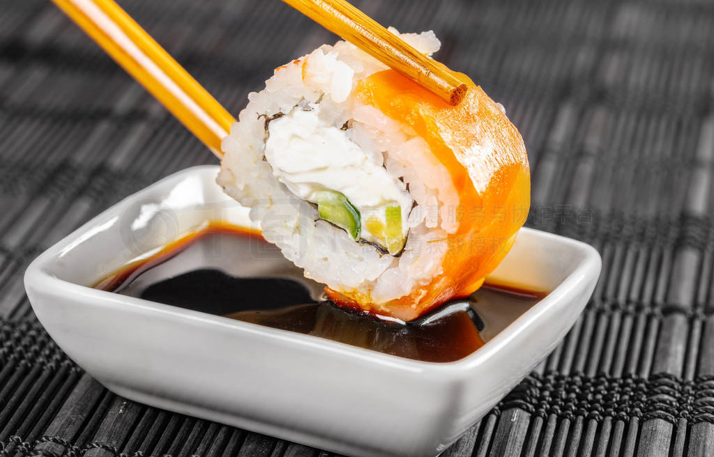 sushi roll dipped in soy sauce