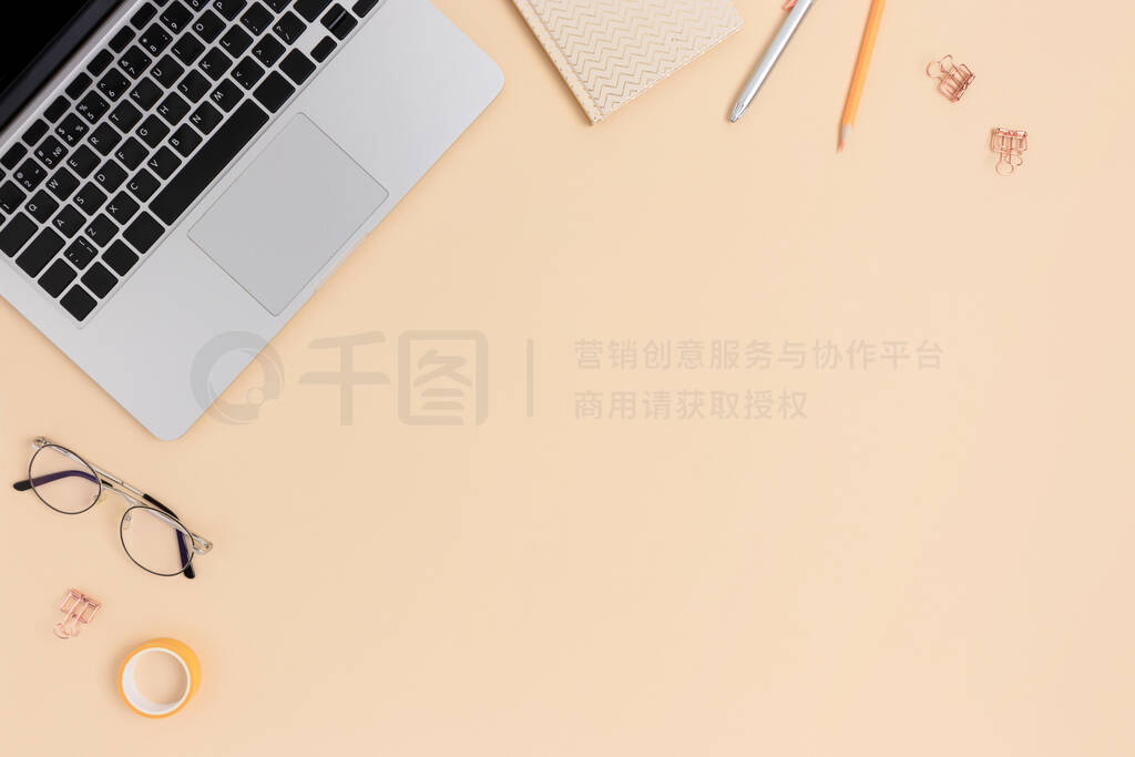 Top view of laptop, glasses and stationery.