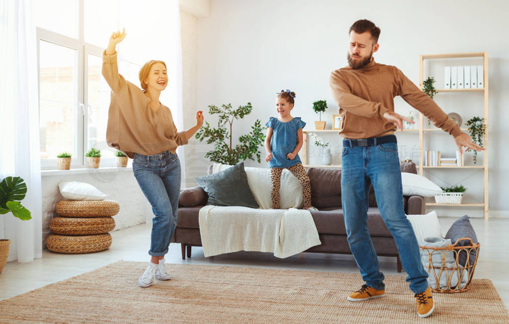 happy family mother father and child daughter dancing at home