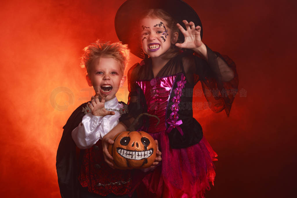 happy children girl and boy in costumes of witch and vampire in