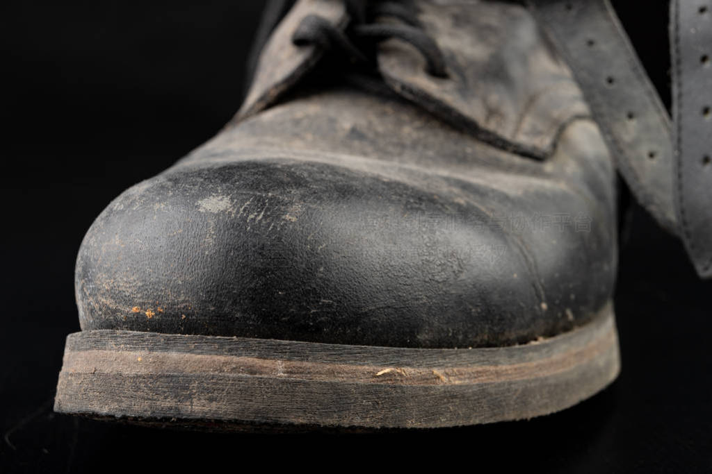 Dirty old black military boots from the mud. Footwear resistant