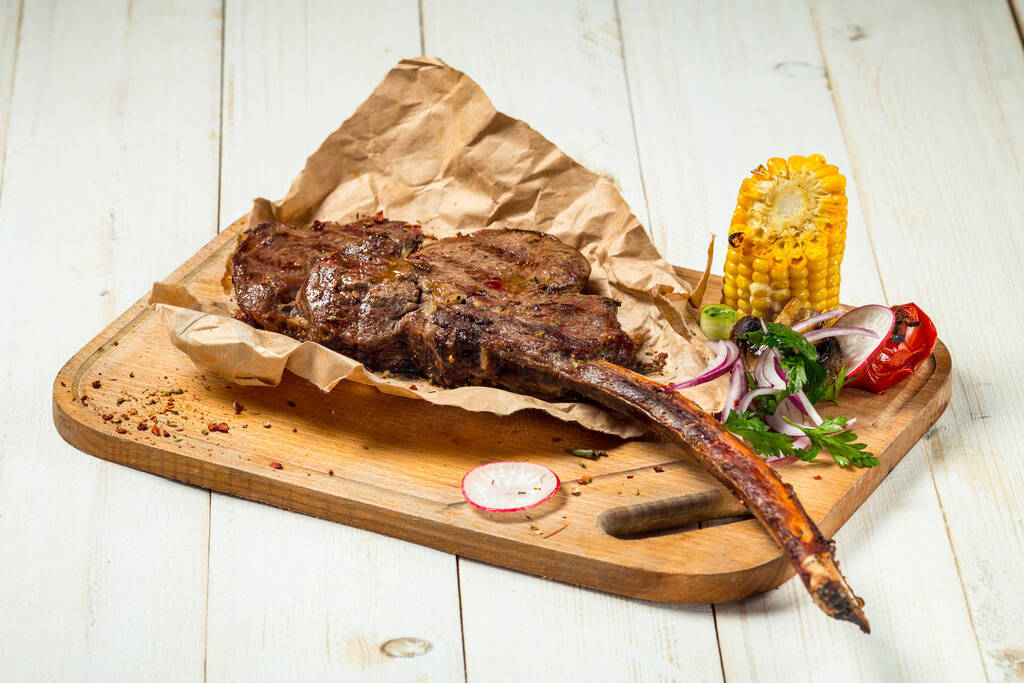 Roasted grilled beef meat steak bone with corn