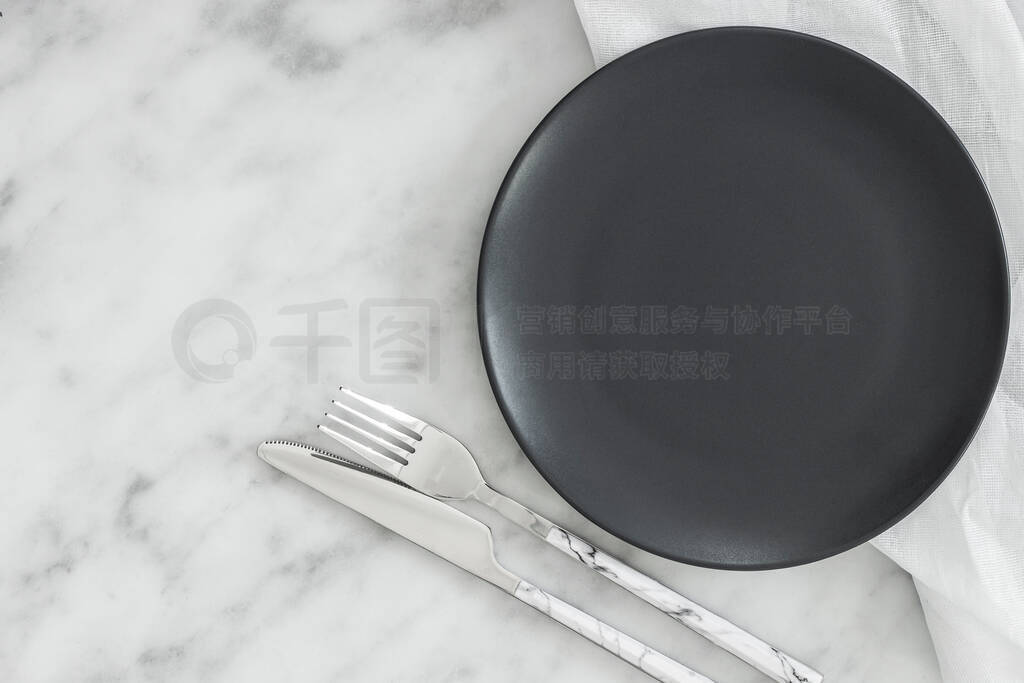 Empty black plate on dark stone background.