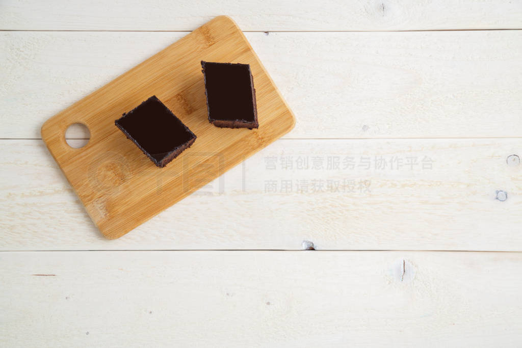 brownie cake on a bamboo tray on a white wooden background with