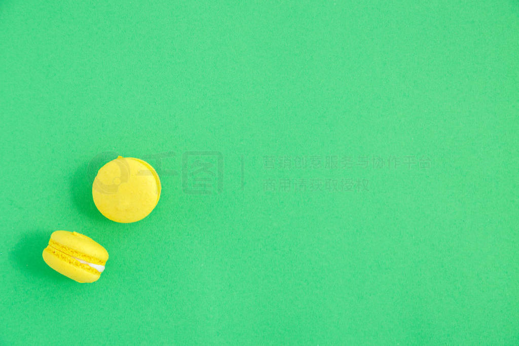 colorful macarons or macaroons cookies on green background. top