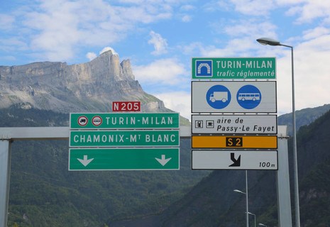 意大利和法国边境的路标，指示使用高速公路隧道前往都灵米兰