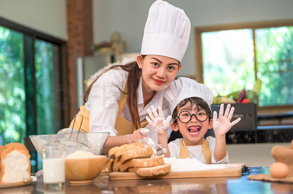 Beautiful woman and cute little Asian boy with eyeglasses, chef