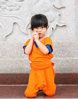 孩子在做冥想表达在泰国,中国庙宇的少林和尚橙色衣服的女孩
