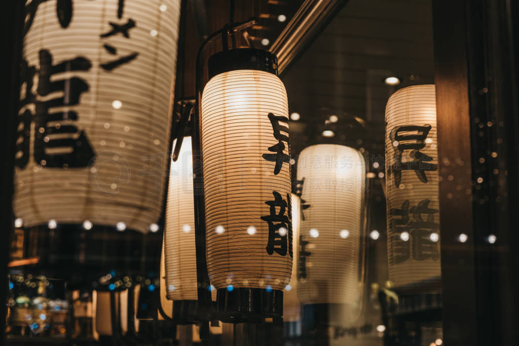Illuminated Japanese lanterns inside a restaurant.