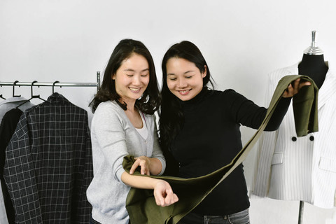 服装店，亚洲时装设计师，在她的展厅工作室工作，服装设计师为客户匹配最佳颜色，创业和小企业主概念。