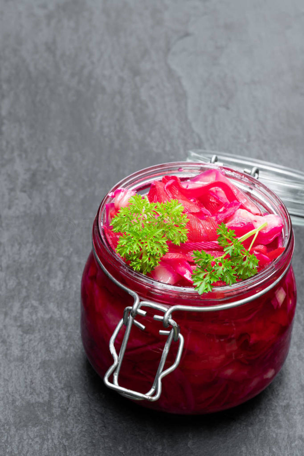 Salad with cabbage and beetroot in glass jar on black stone back
