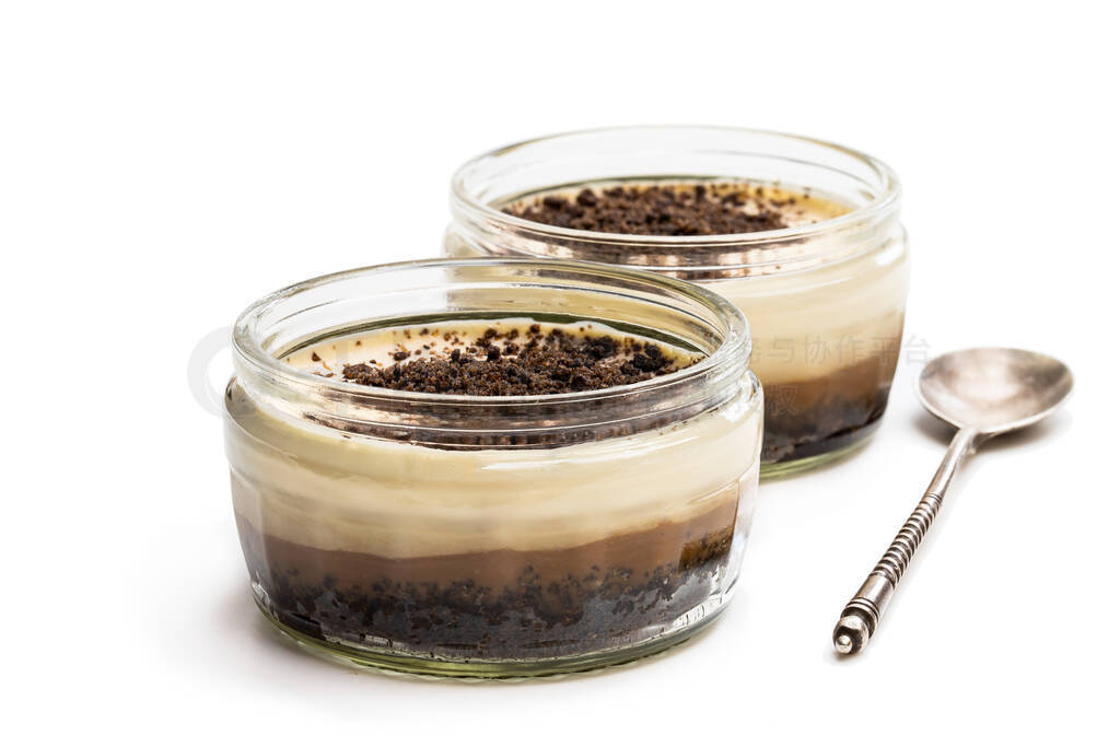 Layered creamy cappuccino cheesecakes in glass jar isolated on w