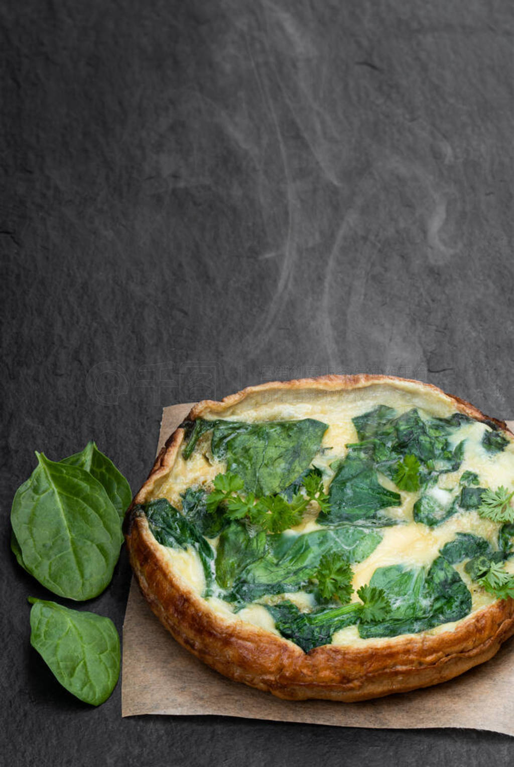 Omelette with spinach on black stone background