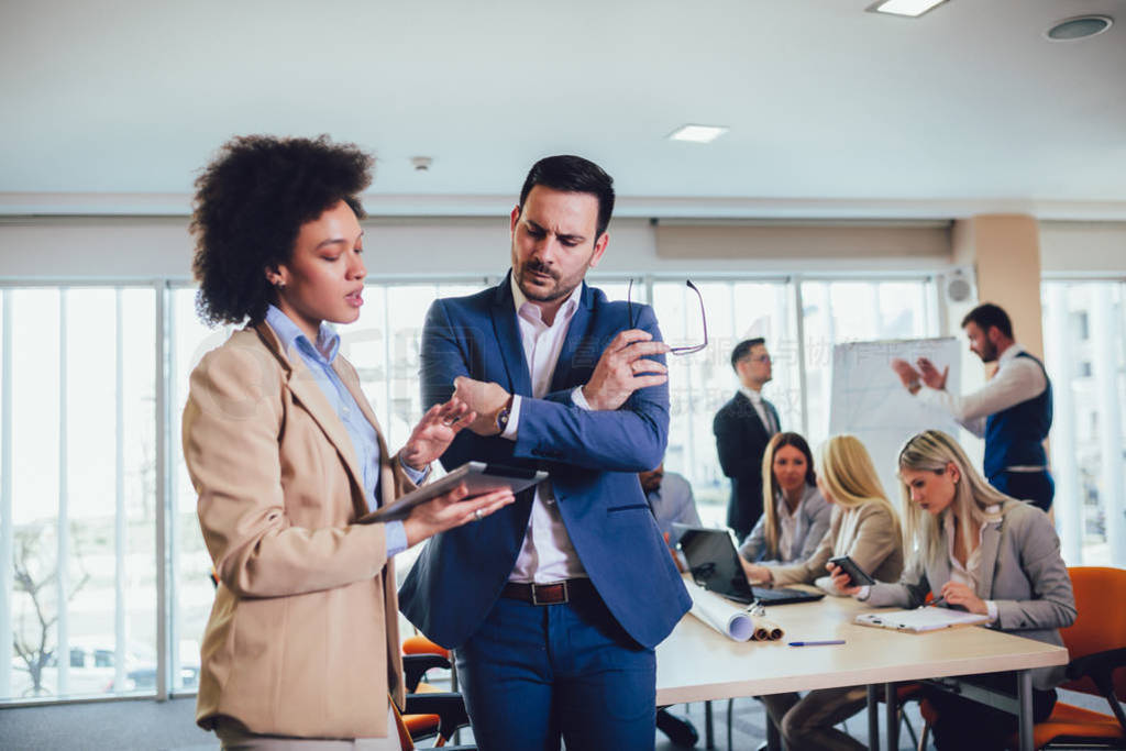 Portrait of two young businesspeople using digital tablet while