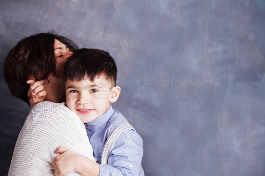 Happy mother and son hugging on chalkboard background