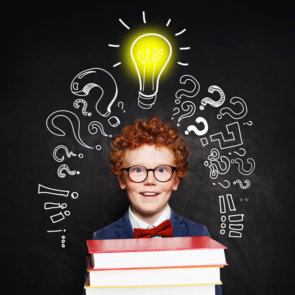 Redhead student child with lightbulb on blackboard background.