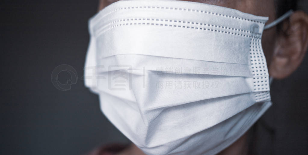 a woman wears a paper face mask over her mouth and nose to prot