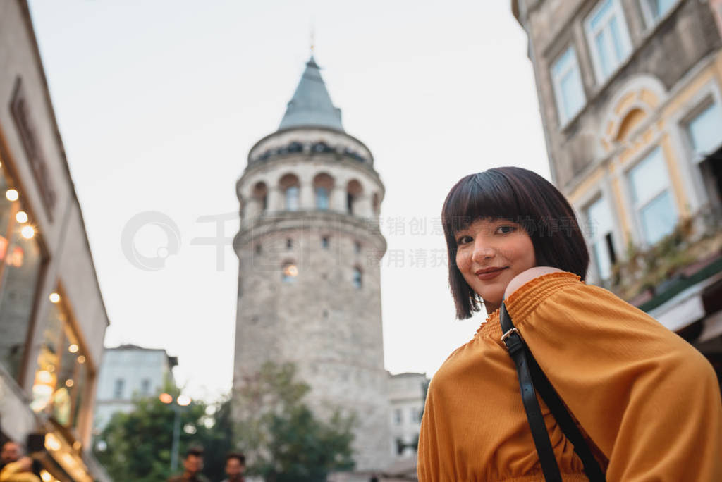 Beautiful woman stands in front of Galata tower