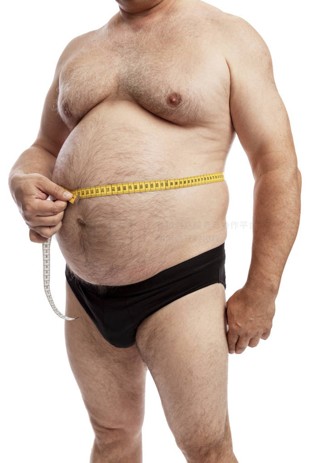 A fat man in shorts measures the volume of the abdomen. Isolated