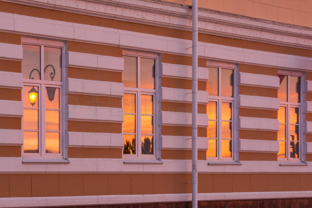 Four windows with the reflection of the sunset and a lantern in