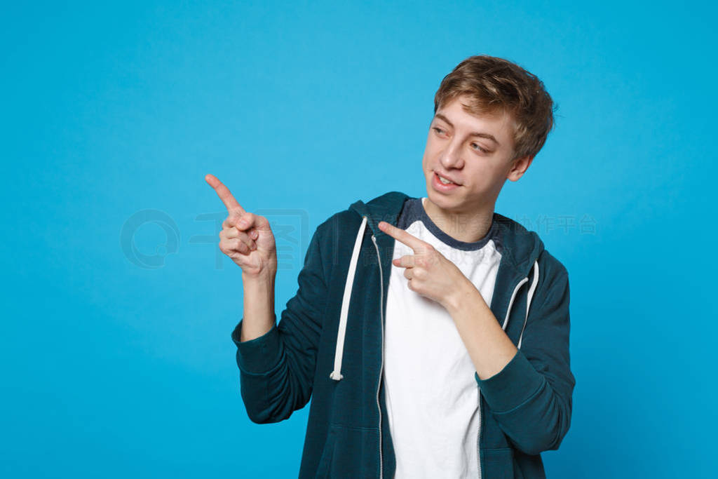 Portrait of young man in casual clothes pointing index fingers,