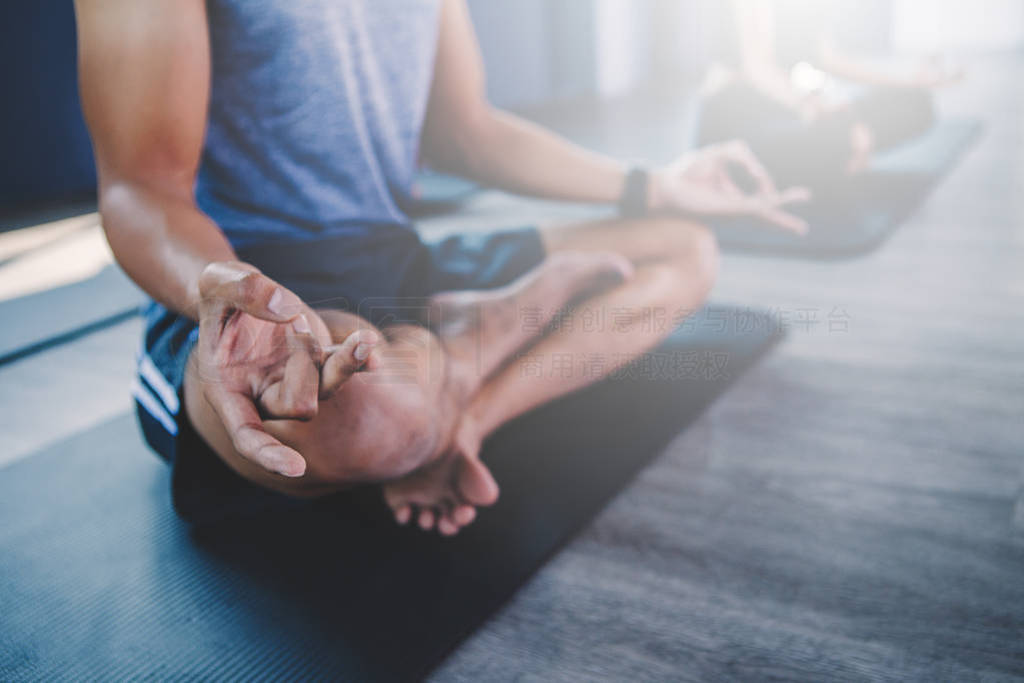 Yoga group concept; young man teaching woman practicing yoga in