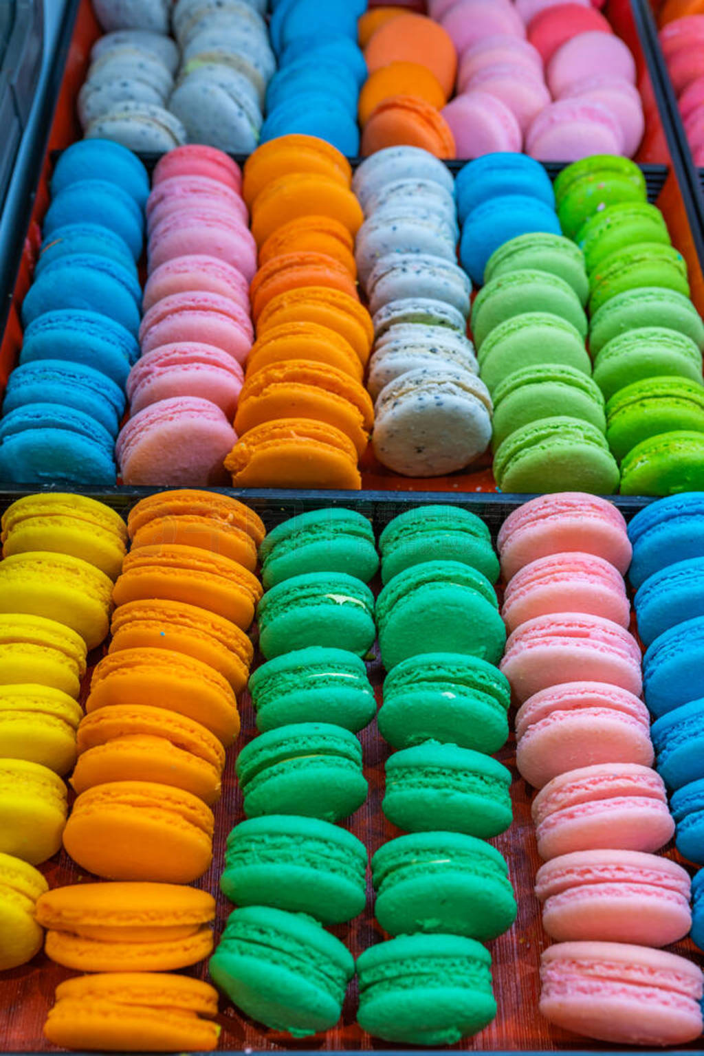 Vertical photo of colorful handmade macaroon cakes in patisserie