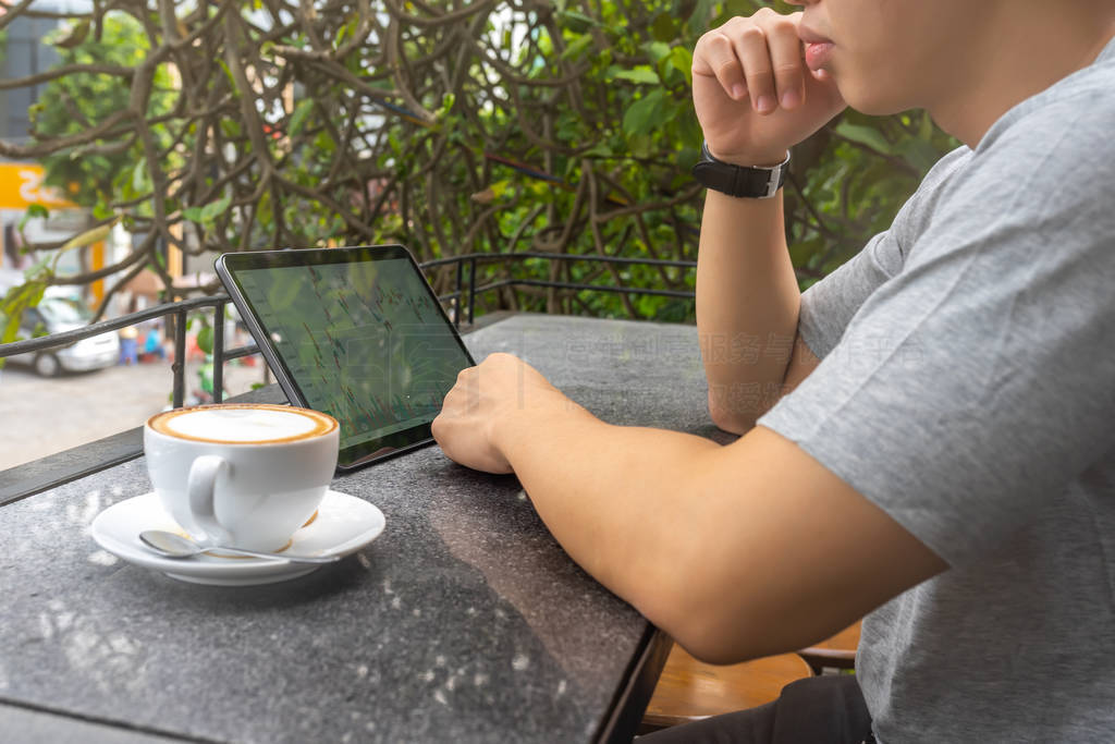 Young freelancer looking at financial candlestick graph on table