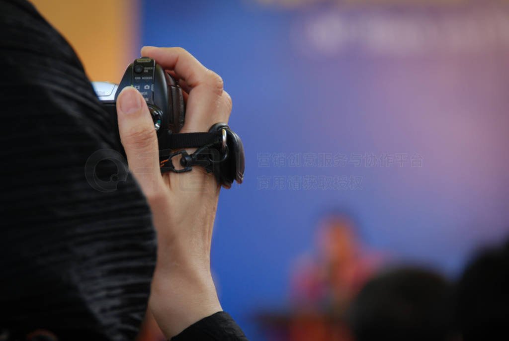 Woman photographer holding a camera and photographing an event