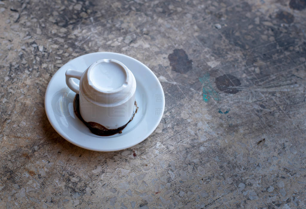 Empty white cup of Cyprus traditional coffee reverted on the dis
