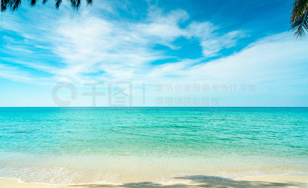 Golden sand beach by the sea with emerald green sea water and bl