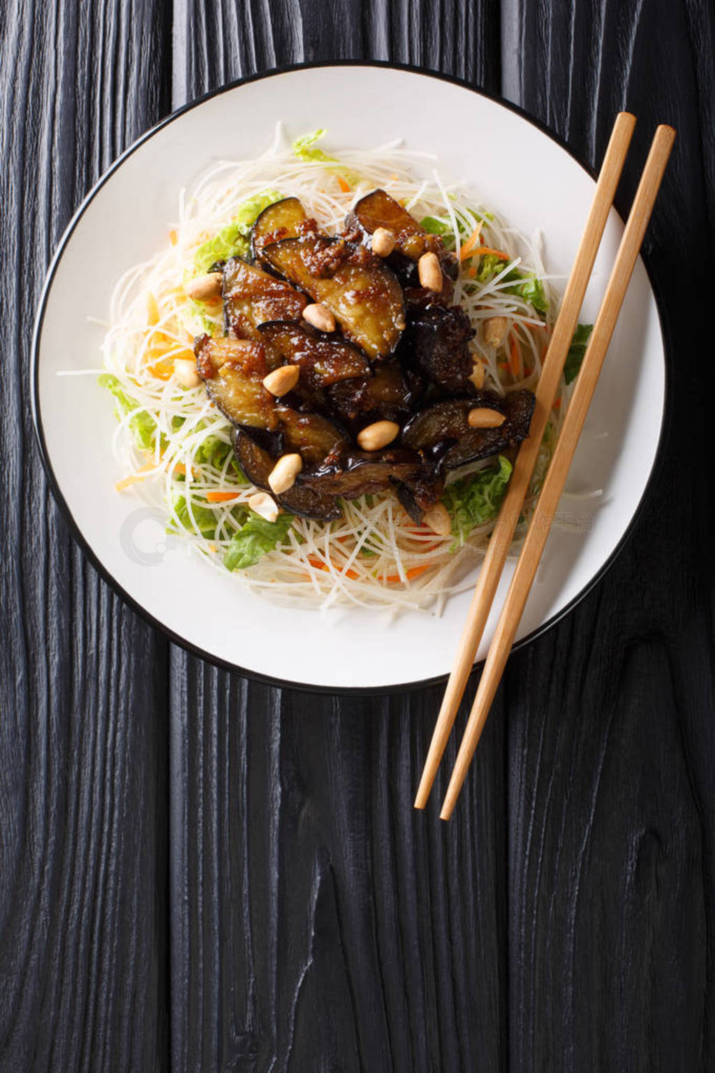 Asian vermicelli with fried eggplants and peanuts close-up on a